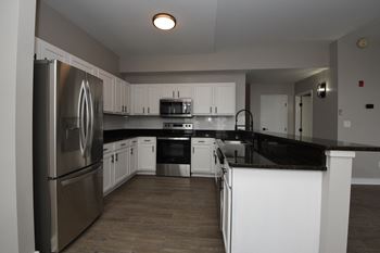 a kitchen with white cabinets and granite countertops